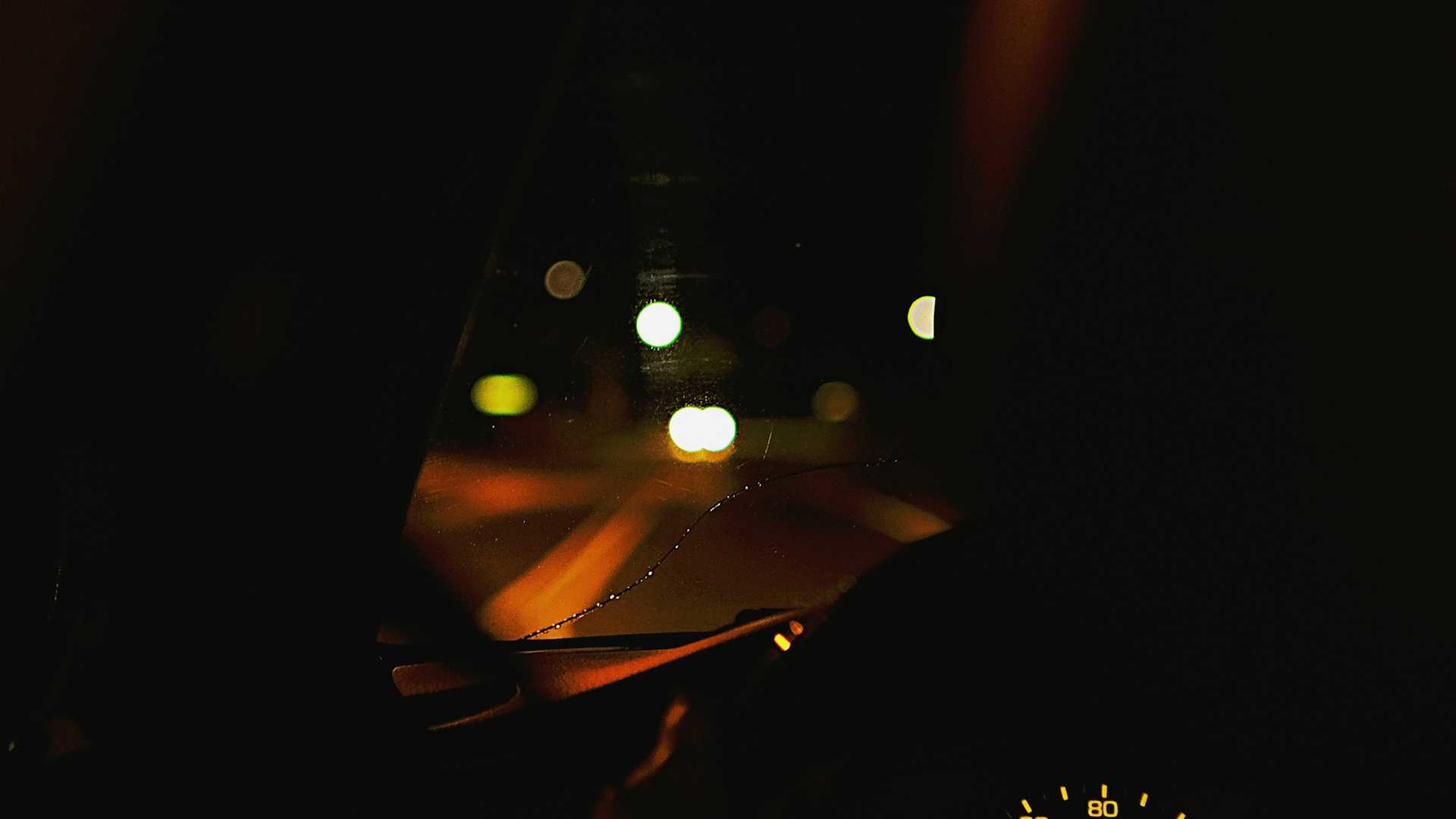 Painel de um carro iluminado à noite, com os instrumentos desfocados