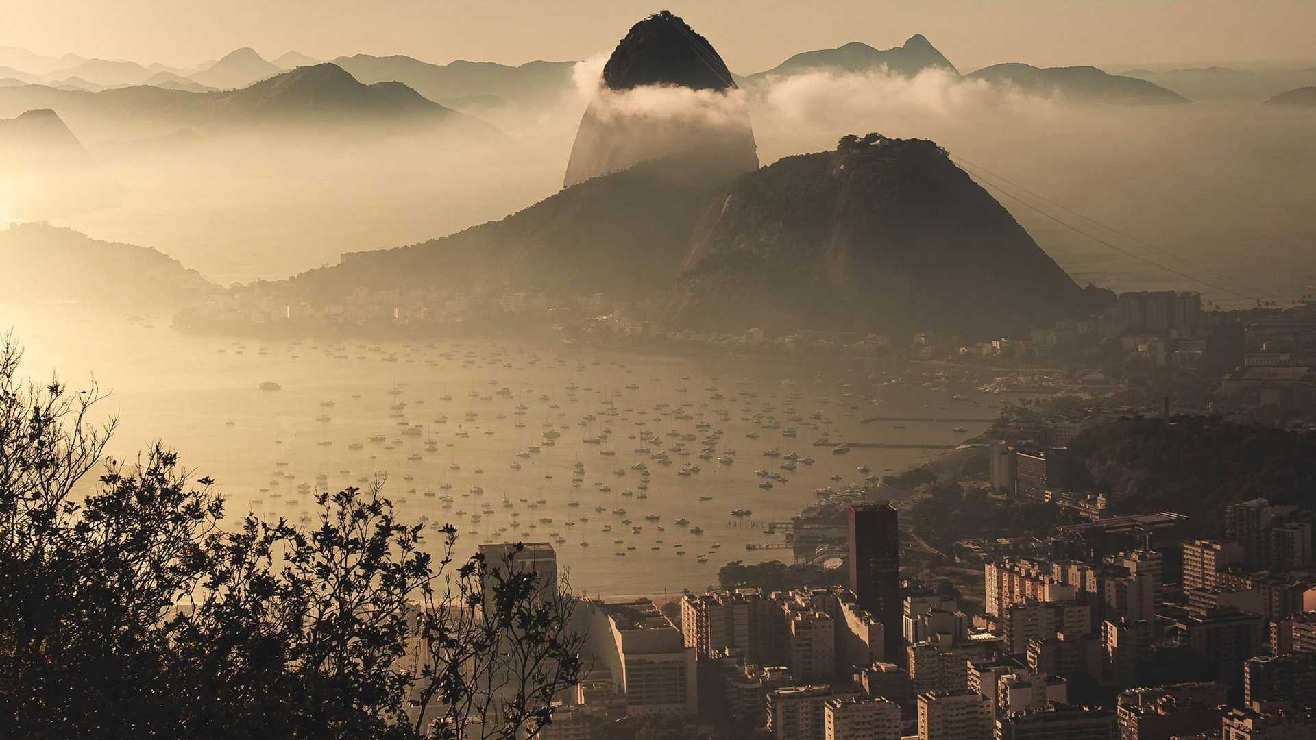 Vista urbana do Rio de Janeiro, com prédios residenciais e o relevo da cidade ao fundo